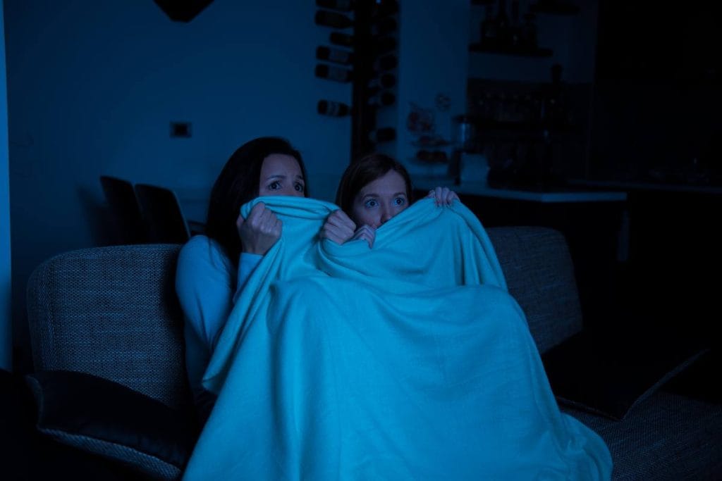 duas adolescentes assustadas assistindo filmes de terror